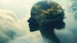 © Olya - Silhouette of a woman's head filled with lush green forest and misty cloudy sky blending nature and human mind