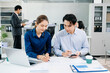 © Nuttapong punna - Young Asian professionals collaborating in modern office, discussing business strategy, teamwork, and success. Perfect for corporate, startup