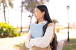 © luismolinero - Pretty Chinese woman at outdoors holding a notebook with happy expression
