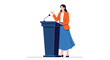 © James - A confident woman in a blazer and skirt stands behind a podium with a microphone, gesturing during a public speech or presentation.