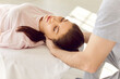 © Studio Romantic - Close-up of male doctor physiotherapist massaging neck to a young Caucasian woman patient lying on the couch in rehabilitation clinic. Physiotherapy and osteopathic medicine concept.
