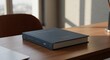 © aby.std - Book on desk near laptop, sunlit room with blurred cityscape background