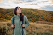© we.bond.creations - Woman with eyes closed, enjoying fresh air and tranquility while hiking in peaceful autumn nature with mountains in background