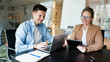 © muse studio - Two colleagues collaborating in a modern office setting, sharing ideas and working on technology