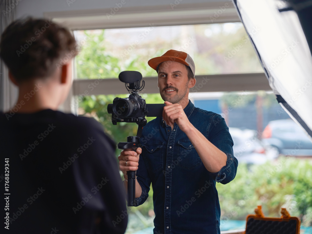 Filmmaker communicating with interview subject while holding stabilized ...