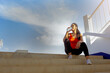 © Panumas - Tired runner woman with a bottle of electrolyte drink freshness after training outdoor workout at the stadium stairway.
