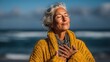 © jiraporn - Middle-Aged Woman Meditating by the Ocean with Hands on Chest