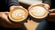 © Siuzenn - Close-up of two people holding matching cups of cappuccino with beautiful rosetta latte art design