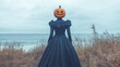 © NJ Tholiya - Woman in a Black Dress with a Pumpkin on Her Head Standing in a Field by the Ocean – Halloween Theme