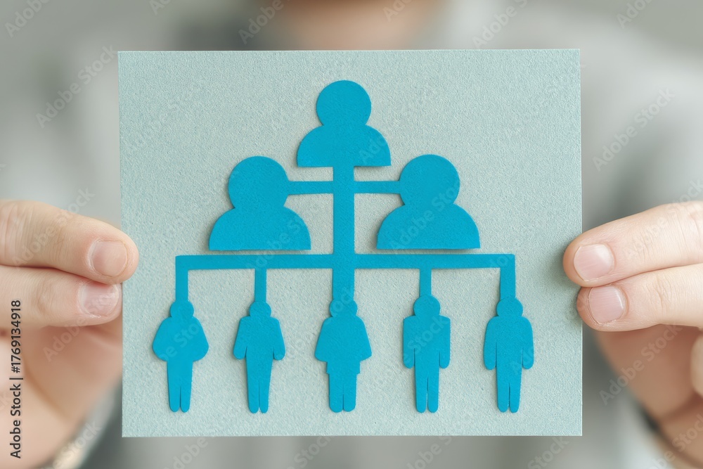 Close up of hands holding papercut organization chart showing hierarchy ...