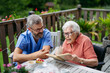 © Halfpoint - Caregiver spending time with elderly woman, reading book.