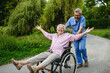 © Halfpoint - Male home nurse pushing elderly woman in wheelchair, having fun.