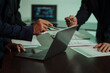 © Thitaporn - Business professionals closely review a balance sheet and digital Global Investment Portfolio data, pointing to key figures, indicating strategic financial planning and rigorous cash flow management.