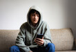 © Praewphan - Cyberbullying, negative in social media online issue in teenager. Upset teen boy sitting near window using smartphone at home.