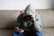 © Praewphan - Cyberbullying, negative in social media online issue in teenager. Upset teen boy sitting near window using smartphone at home.