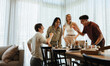© Jacob Lund - Group of friends laughing and bonding around a table with coffee and snacks