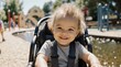 © VisioCraft - Happy toddler with messy blonde hair smiling in a stroller at a park