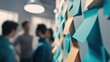 © Антон Сальников - Close-up view of colorful sticky notes on a wall with blurred colleagues meeting in the background