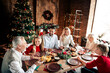 © deagreez - Family Christmas dinner at a cozy home a tree lights glow and joyful mood around a festive table