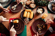 © deagreez - Family Christmas dinner around a festive table with corn on the cob and roasted dishes in a cozy home setting during winter holidays