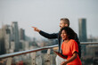 © Halfpoint - Real estate agent talking to client on the rooftop of a modern building