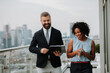 © Halfpoint - Two business people talking on the rooftop terrace of modern office