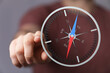 © vegefox.com - Hand touching a compass, a symbol of travel, direction, and guidance, highlighting the concepts of navigation, exploration, and finding your way