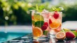 © AndreyFrol - Refreshing summer drink with lemon, lime, strawberry, mint and ice cubes in a clear glass by the pool. A bright, rich composition with natural light creates an atmosphere of relaxation, freshness