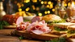 © Maryna - Table with a variety of food items including sandwiches, ham, and pickles. The table is set for a festive occasion, with a Christmas tree in the background