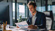 © somegirl - Young business man working looking papers data results happy successful office