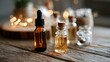 © Juan - Glass dropper bottles on wooden table with candles for aromatherapy, apothecary or essential oil promotional visuals