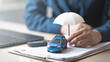 © Garun Studios - insurance, car, policy, coverage, claim, A miniature car with an umbrella on insurance documents symbolizes car insurance policy, financial protection, and risk coverage for vehicles and drivers.