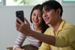 © itchaznong - Couple taking a selfie together with smartphones at home