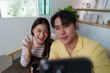 © itchaznong - Cheerful Selfie. Young friends capturing joyful moments with smartphones indoors.