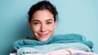 © Salander Studio - smiling young woman leaning her head on a stack of fresh towels