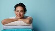 © Salander Studio - smiling young woman leaning her head on a stack of fresh towels