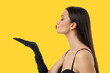 © Atlas - Woman in black top and gloves blowing a kiss