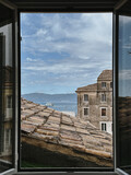 View of Rooftops and Sea from Window