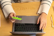 © Studio Marmellata - Crop anonymous woman using green plastic card for online shopping on internet website at home