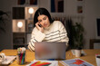 © Studio Marmellata - Young Arab female remote employee in casual clothes speaking via smartphone with client while working on project remotely using laptop