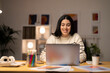 © Studio Marmellata - Young female freelancer in striped sweater sitting at table with laptop working on startup strategy in creative workspace looking at camera