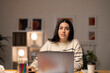 © Studio Marmellata - Young female freelancer in striped sweater sitting at table with laptop working on startup strategy in creative workspace looking at camera