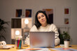© Studio Marmellata - Young female freelancer in striped sweater sitting at table with laptop working on startup strategy in creative workspace looking at camera