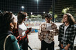© Studio Marmellata - Group of diverse people in casual clothes standing near skate park and discussing about life at night