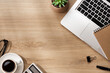 © PixelArt_25 - A morning workspace with a notebook, laptop, coffee, calculator, plant, pen and glasses on a wooden surface, softly lit sunlight from the window.