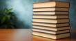 © Urip - A tall stack of hardcover books on a wooden desk for study.