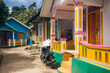 © Connect Images - Vibrantly colored houses with a parked motorcycle under a clear blue sky. Pulau Rhun or Rhun Island, Banda, Central Maluku Regency, Indonesia