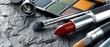 © pvl0707 - Bright red lipstick and makeup brushes arranged on a textured stone surface with an eyeshadow palette in the background during a creative makeup session