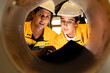 © Montri - Two engineers inspecting the inner surface of a large metal pipe. Wearing safety uniforms and helmets. Concept of industrial inspection, quality control, and manufacturing process.