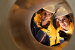 © Montri - Two engineers inspecting the inner surface of a large metal pipe. Wearing safety uniforms and helmets. Concept of industrial inspection, quality control, and manufacturing process.